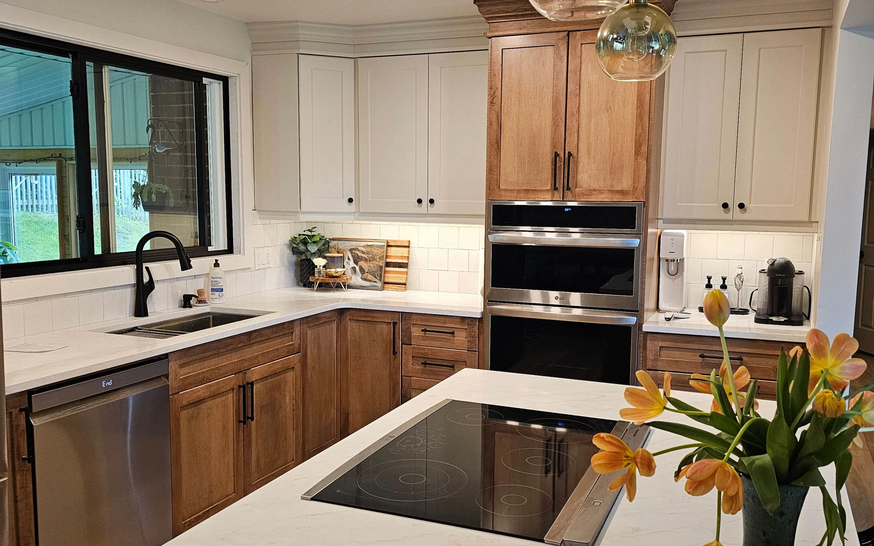 Two tone kitchen with white uppers, natural wood lowers and a quartz counter