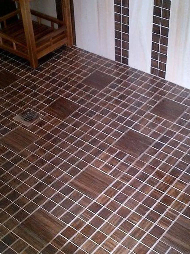 Shower floor in wood look mosaic tile with larger feature squares set into the pattern