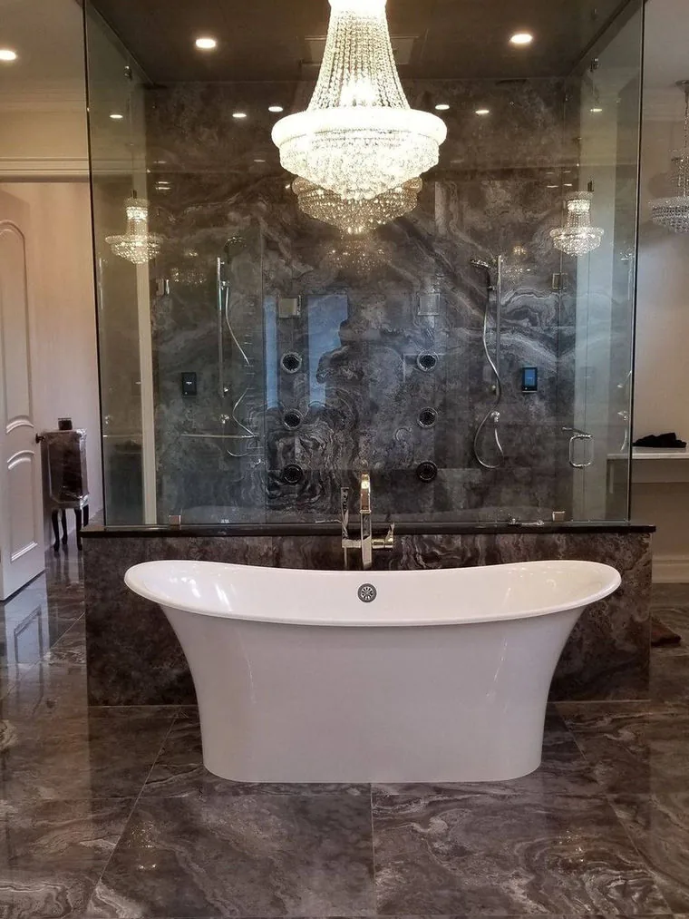 Bathroom renovation with large format marble tile and a freestanding tub